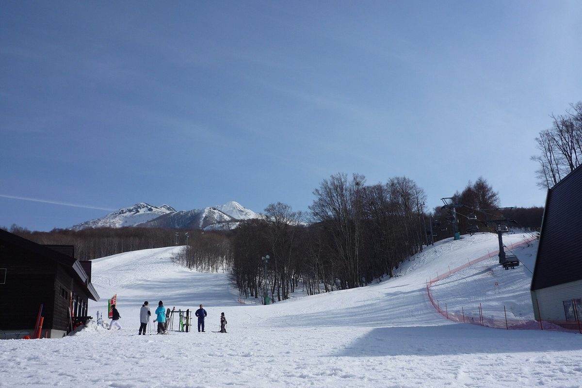 Snow-covered slopes and trees at Aomori Spring, with Mount Iwaki behind