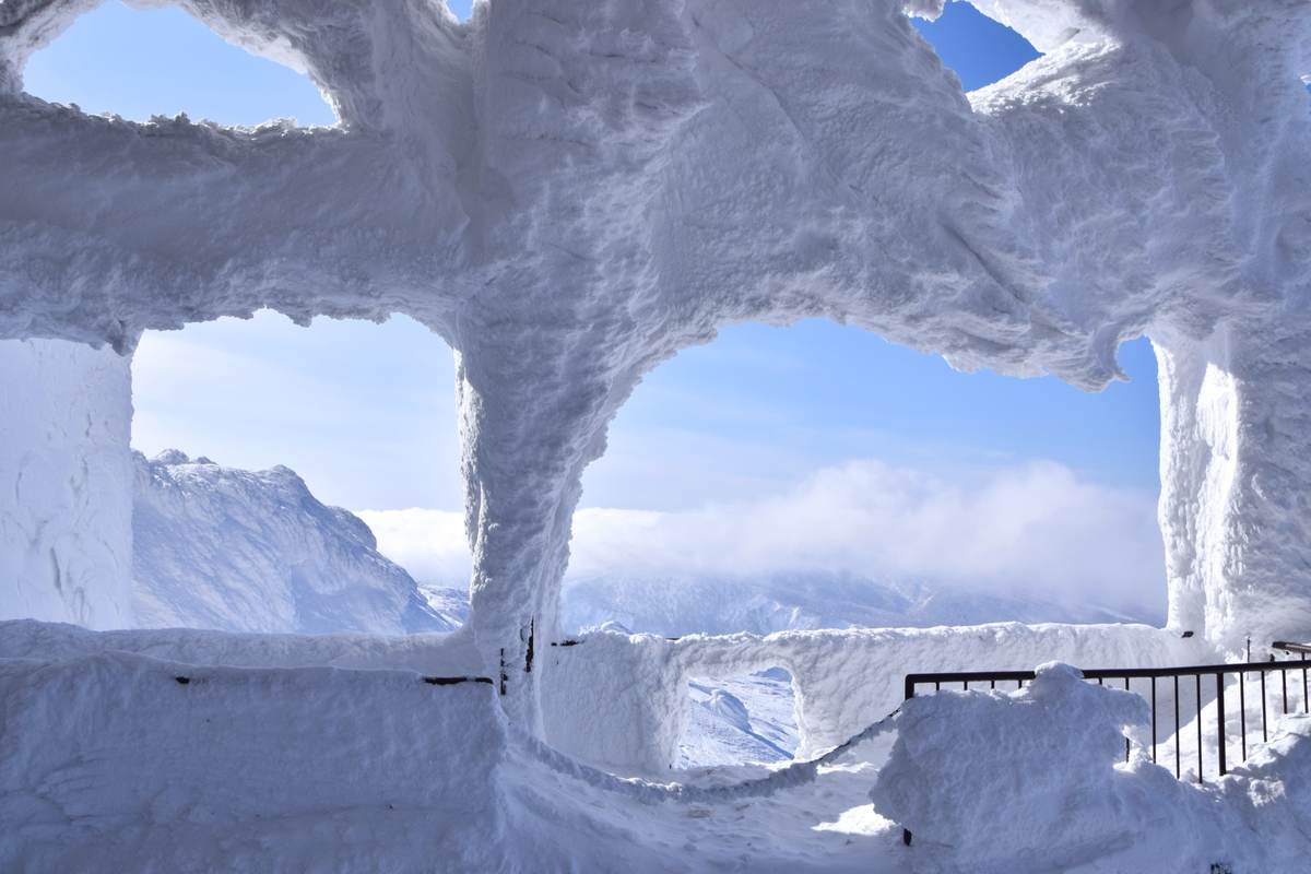 The heavily rime-iced summit station structure at Hakkoda, with the surrounding mountains beyond